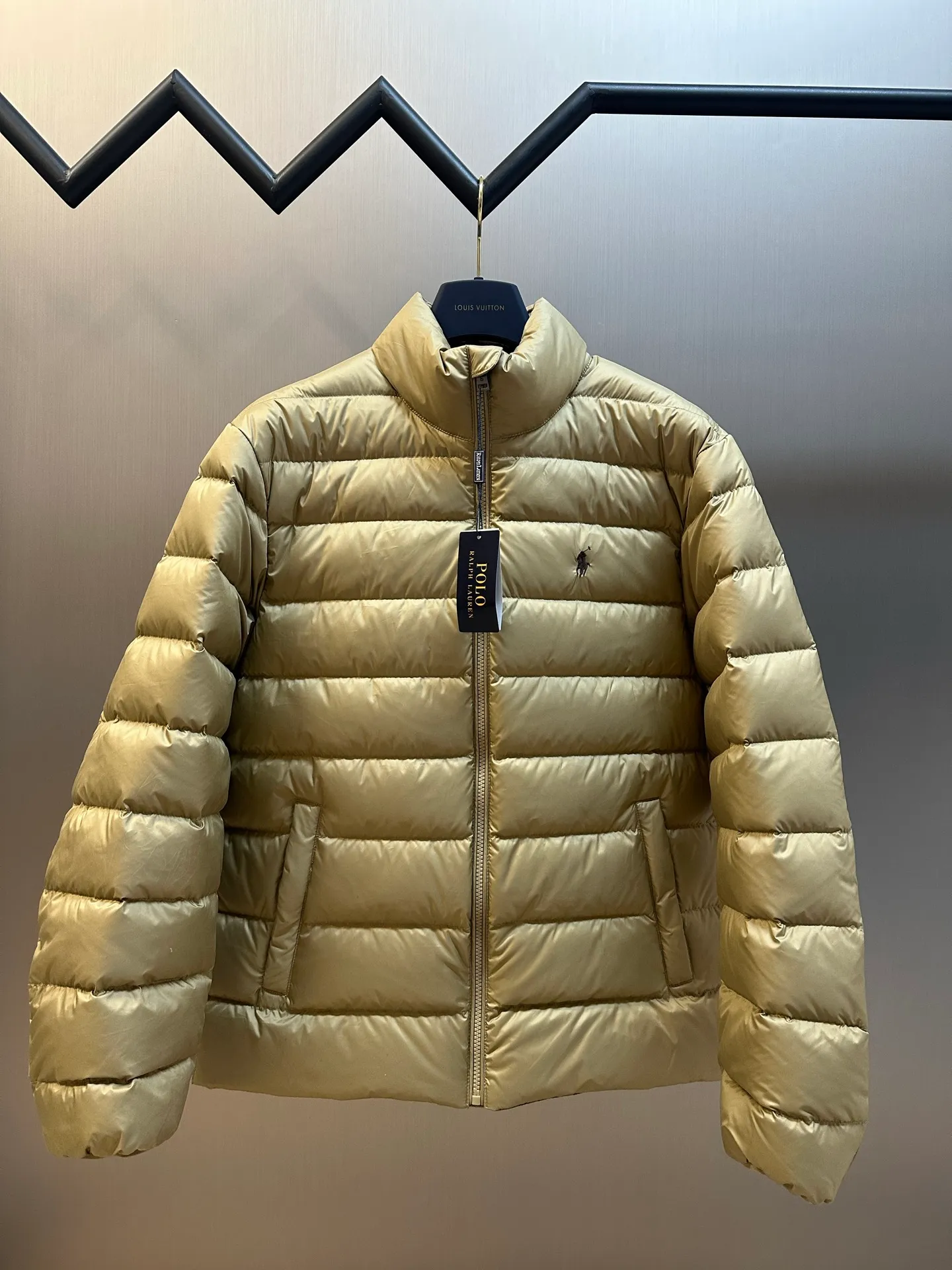 P890 Ralph Lauren lightweight down jacket. The nylon fabric has good windproof and waterproof properties, which can effectively block the intrusion of wind and rain from the outside and keep the inside dry. It is suitable for wearing in humid or rainy environments. The red label on the chest is made with an imported MECLO embroidery machine. The original pattern is scanned first, and then high-quality silk thread is used to make a pattern. The density effect is adjusted by continuous pattern making.  The zipper design is simple and elegant, easy to operate, and the closing design of the cuffs and hem effectively prevents cold wind from invading, improving the warmth and comfort of wearing. It uses 90 white duck down with a weight of 260g to ensure excellent thermal insulation performance. After strict screening and processing, the velvet is not easy to drill, ensuring durability. size: s m l xl